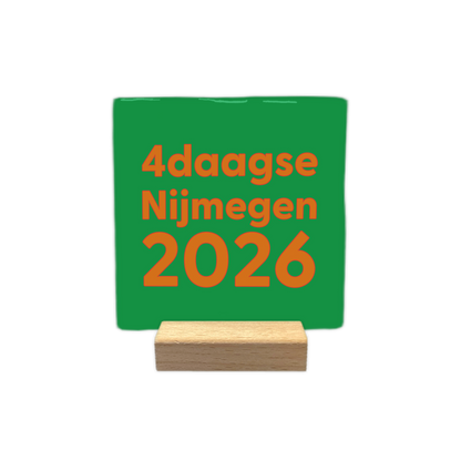 4daagse Nijmegen 2026 - Decoratie tegel - Formaat: - Op deze decoratie tegel staat de tekst "4daagse Nijmegen 2026" in oranje letters, verdeeld over drie regels. De tekst is geplaatst op een heldergroene achtergrond. Het ontwerp maakt gebruik van een strak en dik lettertype. - Snelwenskaart