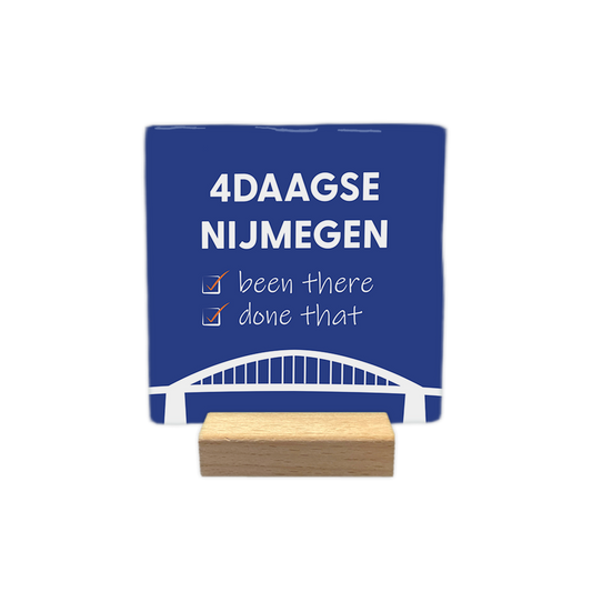 4daagse Nijmegen - Decoratie tegel - Formaat: - Op deze decoratie tegel staat bovenaan de tekst "4daagse Nijmegen" in witte hoofdletters. Daaronder staan twee regels met de tekst "been there" en "done that", waarbij voor elke regel een wit selectievakje met een oranje vinkje is geplaatst. Onderaan het ontwerp is een gestileerde witte afbeelding van een brug zichtbaar. Het geheel is geplaatst op een donkerblauwe achtergrond. - Snelwenskaart