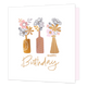 Happy birthday - Formaat: Standaard - Vorm: Vierkant - Verjaardagskaart - Op deze kaart staat de tekst 'Happy birthday' in het goud met daarboven drie vazen in de kleuren goud en roze. In de vazen staan bloemen in het roze, goud en sommige met een zwarte lijn zonder vulling. - Snelwenskaart