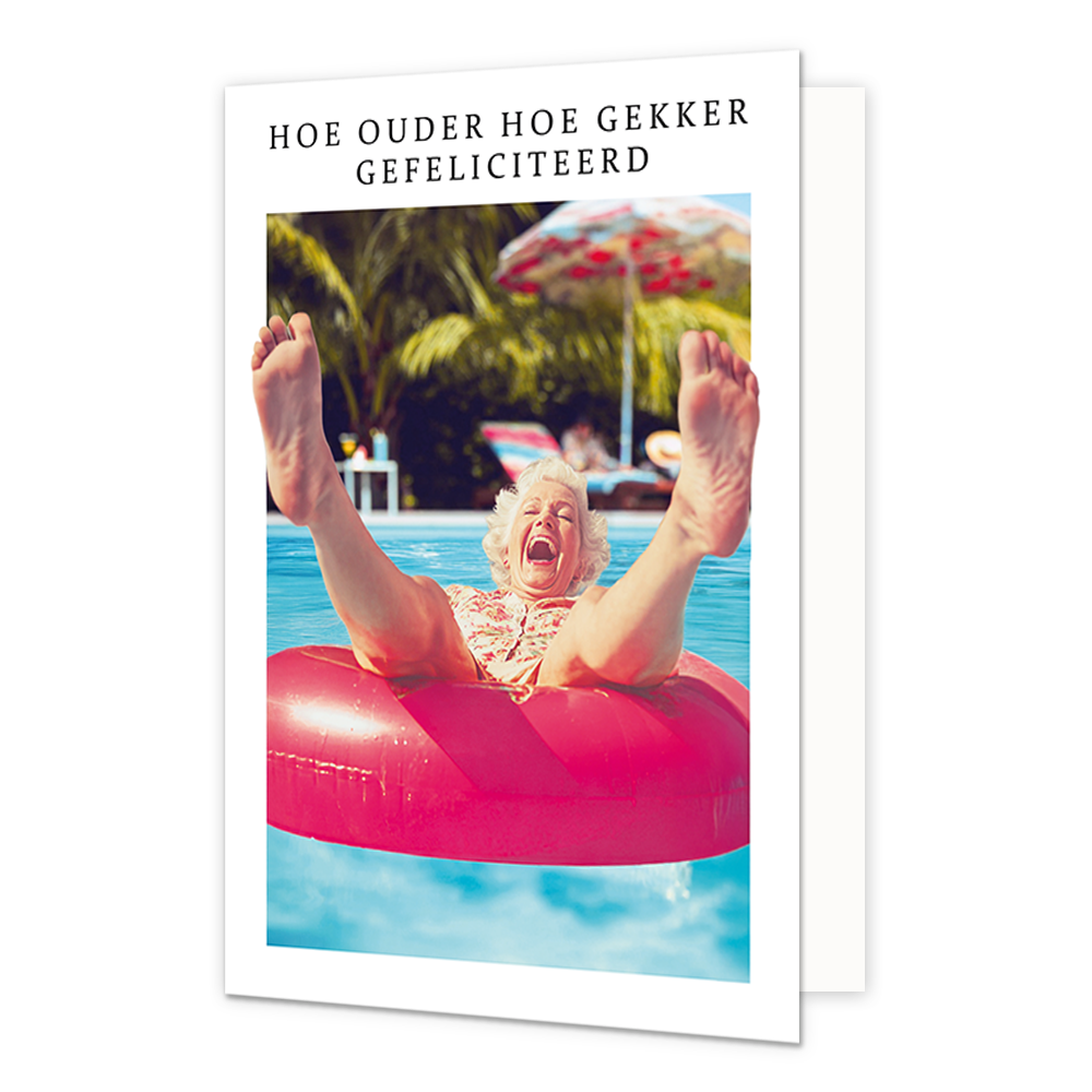 Op deze wenskaart staat een vrouw die in een roze opblaasband ligt met haar benen in de lucht. Om de afbeelding heen staat een wit kader. Bovenin het witte kader staat in het zwart de tekst 'Hoe ouder hoe gekker gefeliciteerd'.