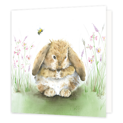 Konijn - Formaat: Standaard - Vorm: Vierkant - Blanco kaart - Op deze wenskaart staat een konijn dat op het gras zit, omringt door bloemen en een bij. - Snelwenskaart