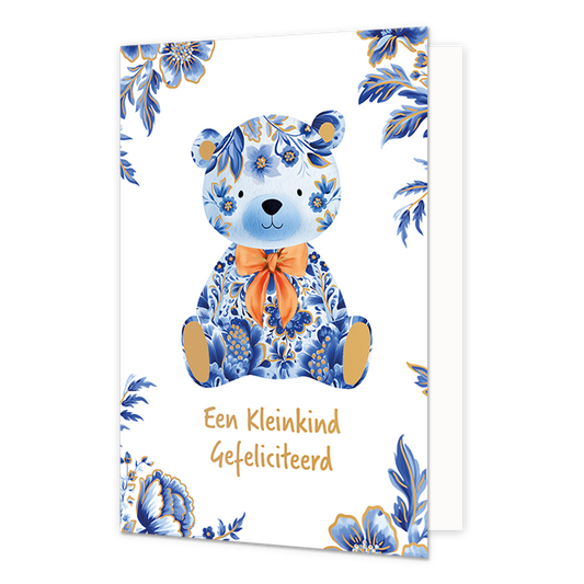 Een kleinkind gefeliciteerd - Afmeting: {"value":12.0,"unit":"CENTIMETERS"} x {"value":17.0,"unit":"CENTIMETERS"} - Formaat: Normaal - Vorm: Staand - Geboortekaart - Op deze wenskaart staat centraal een zittende teddybeer afgebeeld die volledig is gedecoreerd met blauw-witte bloemmotieven in Delfts blauwe stijl, gecombineerd met effen gouden binnenoren en voetzolen. De beer draagt een opvallende, oranje gestrikte sjaal om de nek. De hoeken van de kaart zijn versierd met bijpassende blauwe bloemen en bladere