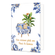 Een nieuwe plek om thuis te komen - Formaat: Normaal - Vorm: Staand - Woningkaart - Op deze wenskaart staat centraal een fauteuil afgebeeld die is bekleed met een blauw-wit bloemenpatroon in Delfts blauwe stijl, voorzien van twee kussens met een goudkleurig dessin en houten pootjes. Direct achter de stoel staat een grote, groene Strelitzia-plant (paradijsvogelbloem) met oranje-blauwe bloemen en goudkleurige randen langs de bladeren. De hoeken van de kaart zijn gedecoreerd met bijpassende blauwe bloemen en 