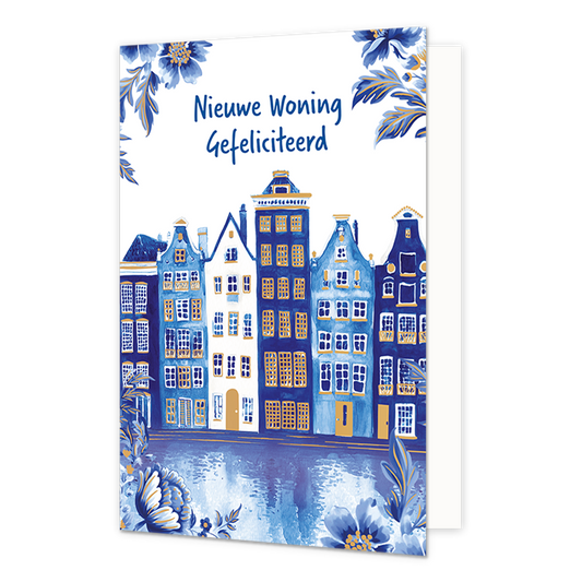 Nieuwe woning gefeliciteerd - Formaat: Normaal - Vorm: Staand - Woningkaart - Op deze wenskaart staat een rij historische grachtenpanden afgebeeld aan het water, geïllustreerd in blauwe en witte tinten in Delfts blauwe stijl met goudkleurige raamkozijnen en details. De weerspiegeling van de gevels is zichtbaar in het water op de voorgrond, en de hoeken van de kaart zijn versierd met bijpassende blauwe bloemen en bladeren met gouden randen. Bovenaan de illustratie staat tegen een witte achtergrond in blauwe