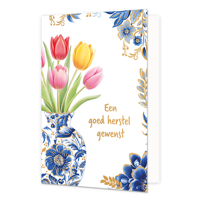 Een goed herstel gewenst - Formaat: Normaal - Vorm: Staand - Beterschapskaart - Op deze wenskaart staat aan de linkerzijde een Delfts blauwe vaas afgebeeld met blauw-witte bloemmotieven en gouden details, gevuld met een boeket van rode, gele en roze tulpen met groene bladeren. De rechterhoeken van de kaart zijn gedecoreerd met bijpassende blauwe bloemen, gouden takjes en bladeren tegen een witte achtergrond. Rechts van de vaas staat in gouden, handgeschreven letters de tekst "Een goed herstel gewenst". - S