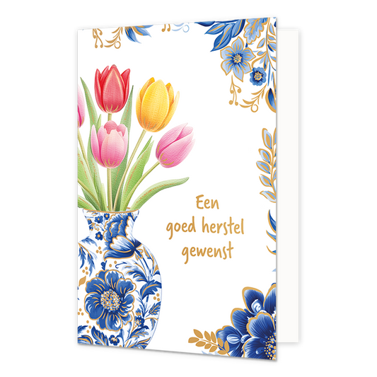 Een goed herstel gewenst - Formaat: Normaal - Vorm: Staand - Beterschapskaart - Op deze wenskaart staat aan de linkerzijde een Delfts blauwe vaas afgebeeld met blauw-witte bloemmotieven en gouden details, gevuld met een boeket van rode, gele en roze tulpen met groene bladeren. De rechterhoeken van de kaart zijn gedecoreerd met bijpassende blauwe bloemen, gouden takjes en bladeren tegen een witte achtergrond. Rechts van de vaas staat in gouden, handgeschreven letters de tekst "Een goed herstel gewenst". - S