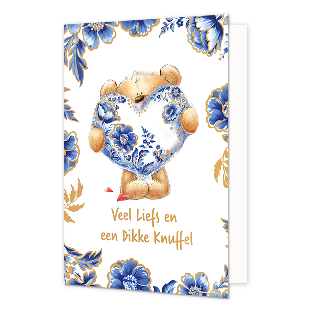  Op deze wenskaart staat centraal een pluche teddybeer afgebeeld die een groot hart vasthoudt dat volledig is versierd met blauw-witte bloemmotieven in Delfts blauwe stijl en goudkleurige stippen. De randen en hoeken van de kaart zijn rijkelijk gedecoreerd met bijpassende blauwe bloemen en bladeren met gouden accenten tegen een witte achtergrond. Onderaan de illustratie staat in goudkleurige, handgeschreven letters de tekst "Veel Liefs en een Dikke Knuffel". 