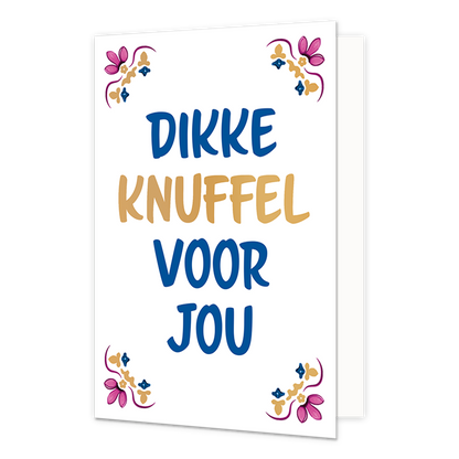 Dikke knuffel voor jou - Formaat: Normaal - Vorm: Staand - Vriendschapskaart - Op deze wenskaart staat centraal een handgeschreven tekst in grote letters tegen een effen witte achtergrond. De volledige tekst luidt onder elkaar geschreven: "Dikke knuffel voor jou", waarbij de woorden "dikke", "voor" en "jou" in het blauw zijn gedrukt en het woord "knuffel" in het goud. In alle vier de hoeken van de kaart bevindt zich een symmetrisch, traditioneel ornament geïnspireerd op een tegelvlak, uitgevoerd in de kleu