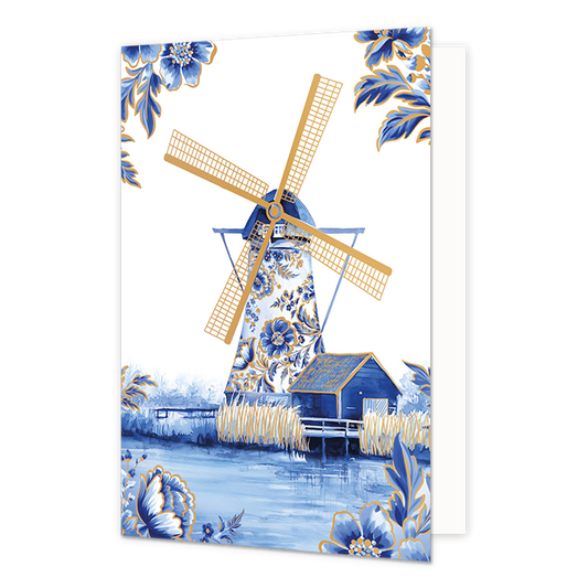 Molen - Formaat: Normaal - Vorm: Staand - Blanco kaart - Op deze wenskaart staat centraal een traditionele windmolen afgebeeld, waarvan de romp volledig is versierd met blauw-witte bloemmotieven in Delfts blauwe stijl en goudkleurige wieken heeft. Naast de molen staat een klein blauw schuurtje met een goudkleurig dak aan de waterkant, omringd door goudkleurige rietstengels en een weerspiegeling in het water op de voorgrond. De hoeken van de kaart zijn op een witte achtergrond gedecoreerd met bijpassende gr