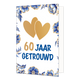 60 jaar getrouwd - Formaat: Standaard - Vorm: Staand - Jubileumkaart - Op deze wenskaart staan centraal twee goudkleurige harten afgebeeld die elkaar deels overlappen tegen een effen witte achtergrond. De randen en hoeken van de kaart zijn rijkelijk versierd met blauw-witte bloemen en bladeren in Delfts blauwe stijl, voorzien van goudkleurige accenten. Onder de harten staat de tekst "60 Jaar Getrouwd" geschreven, waarbij het getal "60" in goudkleurige letters is gedrukt en de woorden "Jaar Getrouwd" in gro