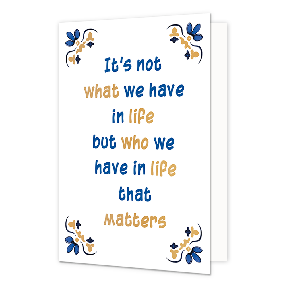 It's not what we have in life - Formaat: Normaal - Vorm: Staand - Denken aan kaart - Op deze wenskaart staat centraal een handgeschreven tekst in blauwe en goudkleurige letters tegen een effen witte achtergrond geschreven. De volledige tekst luidt onder elkaar: "It's not what we have in life but who we have in life that matters". In alle vier de hoeken van de kaart bevindt zich een symmetrisch, traditioneel ornament geïnspireerd op een tegelvlak, uitgevoerd in blauwe en goudkleurige tinten. - Snelwenskaart
