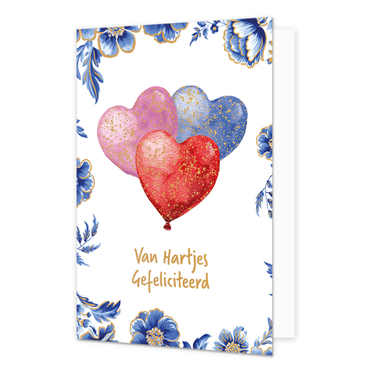 Van hartjes gefeliciteerd - Formaat: Normaal - Vorm: Staand - Felicitatiekaart - Op deze wenskaart staan centraal drie hartvormige ballonnen afgebeeld in de kleuren roze, blauw en rood, welke zijn afgewerkt met goudkleurige spikkels tegen een witte achtergrond. De randen en hoeken van de kaart zijn rijkelijk gedecoreerd met blauw-witte bloemen en bladeren in Delfts blauwe stijl met fijne goudkleurige randen. Onder de ballonnen staat in goudkleurige, handgeschreven letters de tekst "Van Hartjes Gefeliciteer