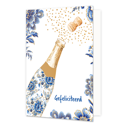 Gefeliciteerd - Formaat: Normaal - Vorm: Staand - Felicitatiekaart - Op deze wenskaart staat aan de linkerzijde een openspringende champagnefles afgebeeld, waarvan de fles is gedecoreerd met blauw-witte bloemmotieven in Delfts blauwe stijl en de kurk met goudkleurige bubbels naar rechtsboven wegvliegt. De randen en hoeken van de kaart zijn op een witte achtergrond rijkelijk versierd met bijpassende grote blauwe bloemen en bladeren met gouden accenten. Rechtsonder de fles staat in blauwe letters de tekst "G