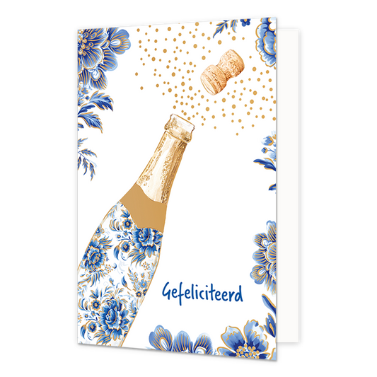Gefeliciteerd - Formaat: Normaal - Vorm: Staand - Felicitatiekaart - Op deze wenskaart staat aan de linkerzijde een openspringende champagnefles afgebeeld, waarvan de fles is gedecoreerd met blauw-witte bloemmotieven in Delfts blauwe stijl en de kurk met goudkleurige bubbels naar rechtsboven wegvliegt. De randen en hoeken van de kaart zijn op een witte achtergrond rijkelijk versierd met bijpassende grote blauwe bloemen en bladeren met gouden accenten. Rechtsonder de fles staat in blauwe letters de tekst "G