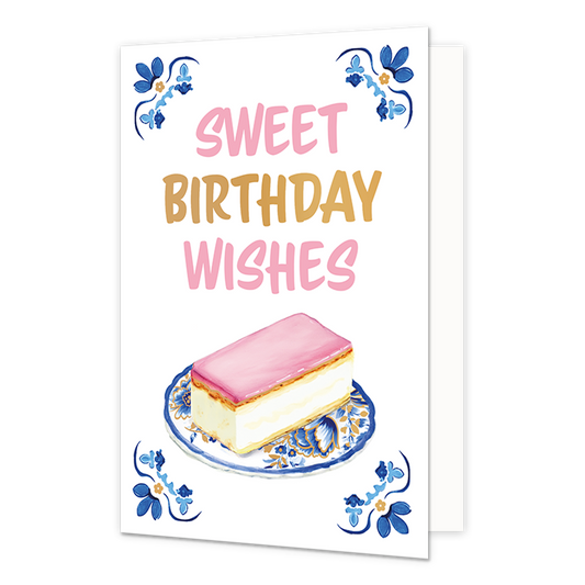 Sweet birthday wishes - Formaat: Normaal - Vorm: Staand - Verjaardagskaart - Op deze wenskaart staat aan de onderzijde een tompouce met een roze glazuurlaag afgebeeld op een gebaksbordje dat is versierd met blauw-witte bloemmotieven in Delfts blauwe stijl en gouden accenten. In de vier hoeken van de kaart bevindt zich een symmetrisch, traditioneel blauw met goudkleurig ornament tegen een witte achtergrond. Boven het gebakje staat in grote letters de tekst "Sweet Birthday Wishes" geschreven, waarbij de woor