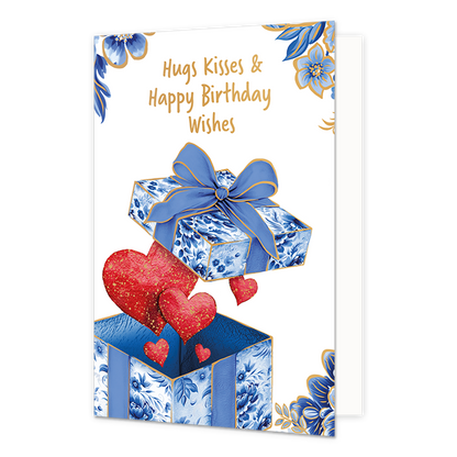 Hugs kisses & happy birthday wishes - Formaat: Normaal - Vorm: Staand - Verjaardagskaart - Op deze wenskaart staat aan de onderzijde een geopende cadeaudoos afgebeeld waaruit rode harten met goudkleurige spikkels omhoog zweven. Zowel de doos als het zwevende deksel met de grote blauwe strik zijn gedecoreerd met blauw-witte bloemmotieven in Delfts blauwe stijl en voorzien van fijne goudkleurige randen. De hoeken van de kaart zijn op een witte achtergrond versierd met bijpassende grote blauwe bloemen en blad