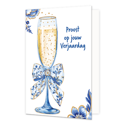 Proost op jouw verjaardag - Formaat: Normaal - Vorm: Staand - Verjaardagskaart - Op deze wenskaart staat aan de linkerzijde een gevuld champagneglas afgebeeld met een goudkleurige, bruisende inhoud en een grote strik om de steel die gedecoreerd is met blauw-witte bloemmotieven in Delfts blauwe stijl. De hoeken linksboven en rechtsonder zijn op een witte achtergrond versierd met bijpassende grote blauwe bloemen en bladeren met fijne goudkleurige randen. Aan de rechterzijde van het glas staat in blauwe lette