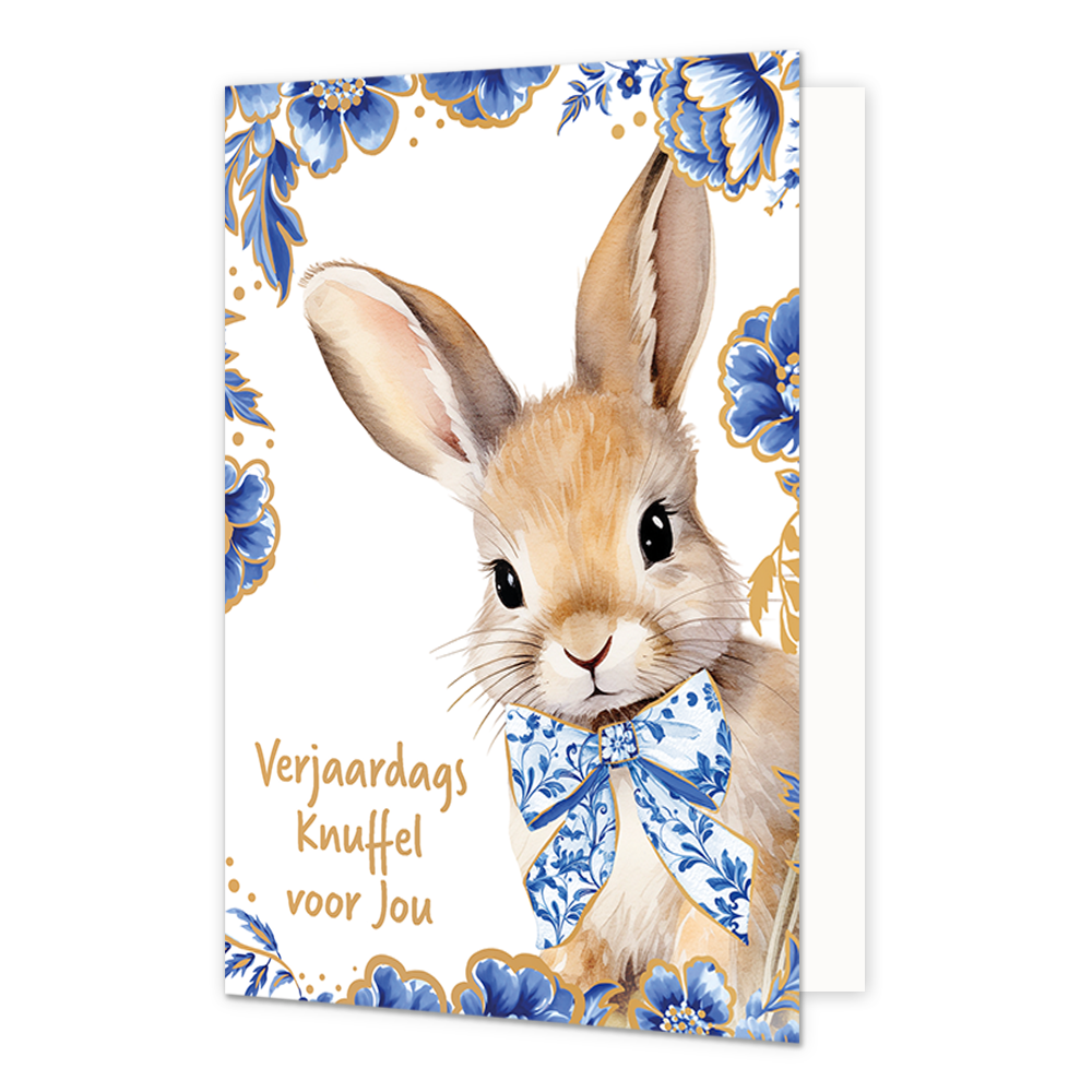 Verjaardags knuffel voor jou - Formaat: Normaal - Vorm: Staand - Verjaardagskaart - Op deze wenskaart staat aan de rechterzijde een getekend bruin konijn afgebeeld dat een grote strik om de hals draagt die gedecoreerd is met blauw-witte bloemmotieven in Delfts blauwe stijl. De randen en hoeken van de kaart zijn op een witte achtergrond rijkelijk versierd met bijpassende grote blauwe bloemen en bladeren met fijne goudkleurige randen. Aan de linkerzijde staat in goudkleurige letters onder elkaar de tekst "Ve
