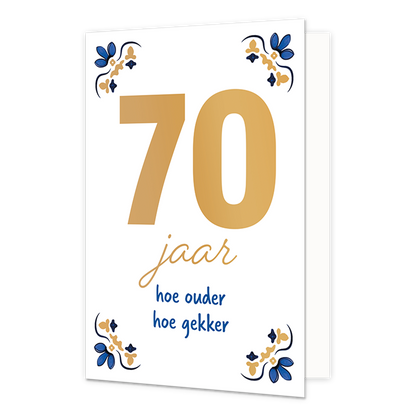 70 jaar - Formaat: Normaal - Vorm: Staand - Verjaardagskaart - Op deze wenskaart staat centraal het grote getal "70" in goudkleurige letters afgebeeld tegen een effen witte achtergrond. In de vier hoeken van de kaart bevindt zich een symmetrisch, traditioneel ornament in blauwe en goudkleurige tinten, geïnspireerd op een klassiek tegelontwerp. Onder het getal staat de handgeschreven tekst "jaar hoe ouder hoe gekker", waarbij het woord "jaar" in het goud is gedrukt en de zin "hoe ouder hoe gekker" in blauwe