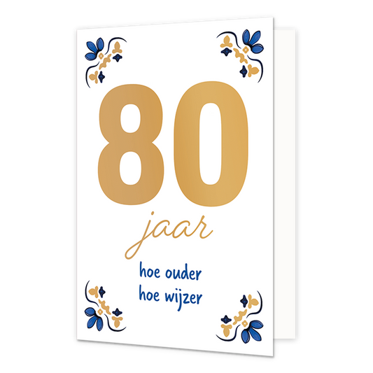 80 jaar - Formaat: Normaal - Vorm: Staand - Verjaardagskaart - Op deze wenskaart staat centraal het grote getal "80" in goudkleurige letters afgebeeld tegen een effen witte achtergrond. In de vier hoeken van de kaart bevindt zich een symmetrisch, traditioneel ornament in blauwe en goudkleurige tinten, geïnspireerd op een klassiek tegelontwerp. Onder het getal staat de handgeschreven tekst "jaar hoe ouder hoe wijzer", waarbij het woord "jaar" in het goud is gedrukt en de zin "hoe ouder hoe wijzer" in blauwe