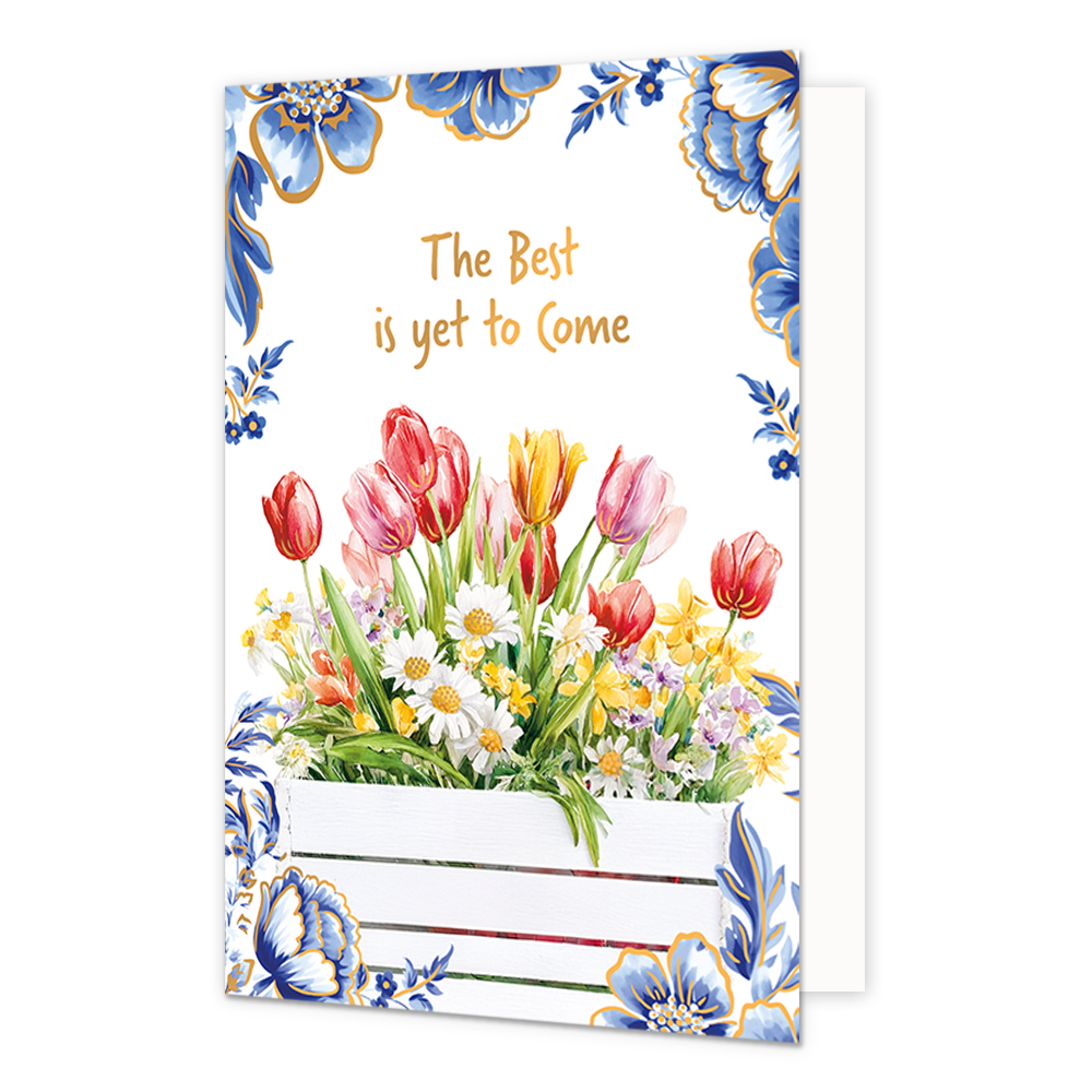 The best is yet to come - Formaat: Normaal - Vorm: Staand - Blanco kaart - Op deze wenskaart staat aan de onderzijde een witte houten plantenbak gevuld met een kleurrijk boeket van rode, roze en gele tulpen, witte madeliefjes en andere voorjaarsbloemen afgebeeld. De hoeken en randen van de kaart zijn op een witte achtergrond rijkelijk versierd met grote blauwe bloemen en bladeren in Delfts blauwe stijl met goudkleurige randen. Centraal aan de bovenzijde staat in goudkleurige letters onder elkaar de tekst "