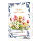 The best is yet to come - Formaat: Normaal - Vorm: Staand - Blanco kaart - Op deze wenskaart staat aan de onderzijde een witte houten plantenbak gevuld met een kleurrijk boeket van rode, roze en gele tulpen, witte madeliefjes en andere voorjaarsbloemen afgebeeld. De hoeken en randen van de kaart zijn op een witte achtergrond rijkelijk versierd met grote blauwe bloemen en bladeren in Delfts blauwe stijl met goudkleurige randen. Centraal aan de bovenzijde staat in goudkleurige letters onder elkaar de tekst "