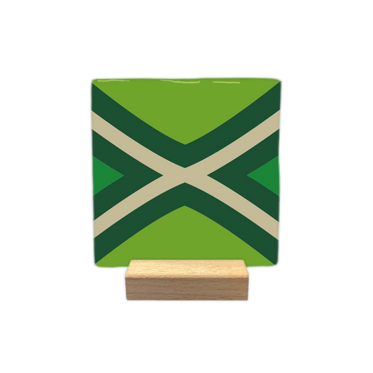 Achterhoekse vlag - Decoratie tegel - Formaat: - Op deze decoratie tegel is een geometrisch patroon in verschillende groentinten en beige te zien. Het ontwerp bestaat uit twee gekruiste lijnen in het midden die een x-vorm vormen met beige stroken. Rondom deze lijnen bevinden zich donkergroene banen die het patroon verder verdelen. De overige vlakken van de tegel zijn ingevuld met een lichtere tint groen. - Snelwenskaart