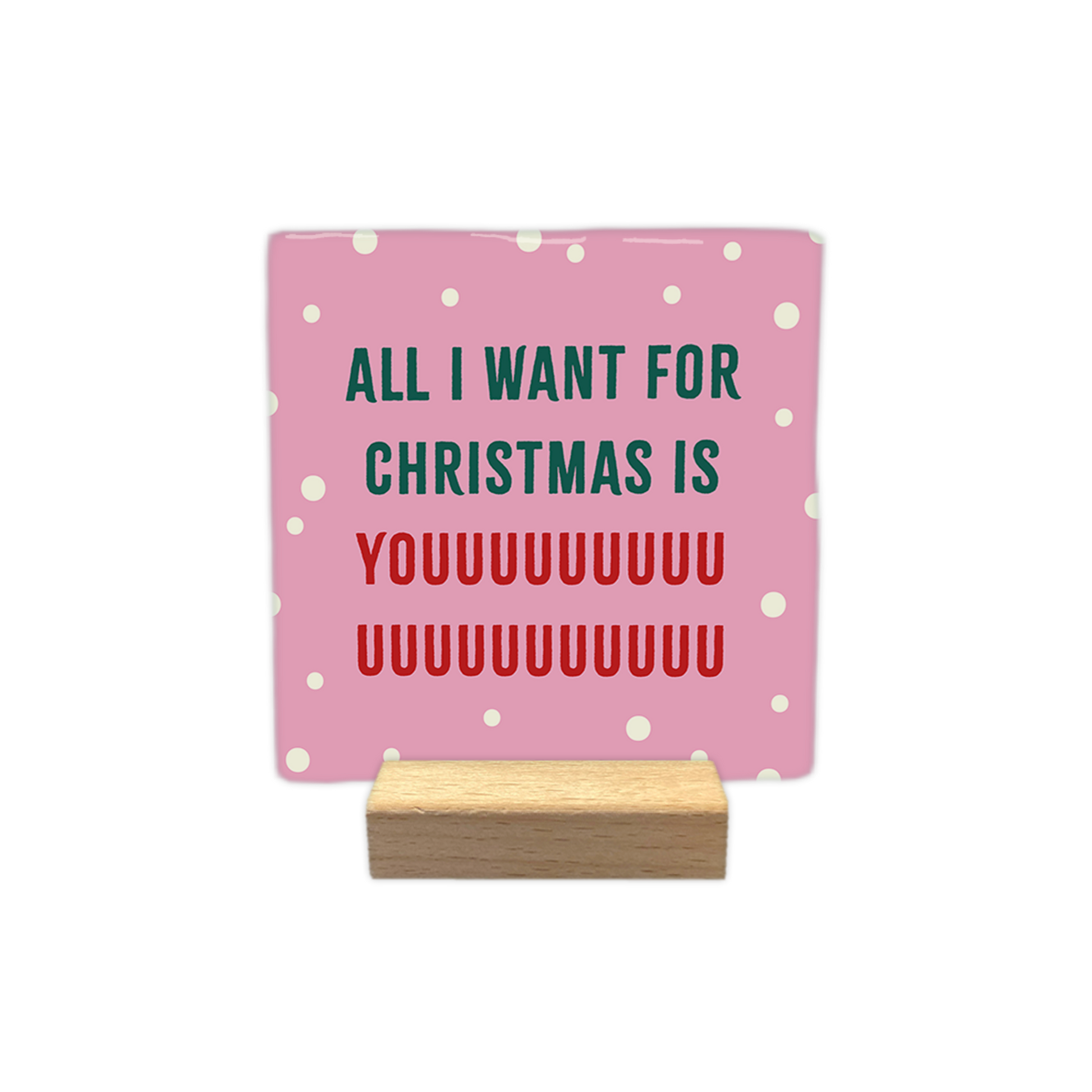 All I want for christmas is you - Decoratie tegel - Formaat: - Op deze decoratie tegel staat een roze achtergrond met kleine witte stippen. In het midden staat de tekst all i want for christmas is youuuu... in groene en rode letters geschreven. - Snelwenskaart