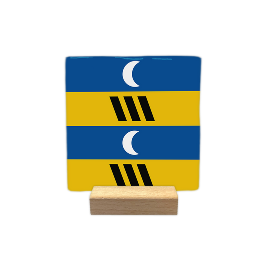 Ameland - Decoratie tegel - Formaat: - Op deze decoratie tegel zijn horizontale banen in blauw en geel te zien. In de twee blauwe banen is telkens een witte halve maan geplaatst. De twee gele banen bevatten elk drie schuin geplaatste zwarte balkjes. - Snelwenskaart