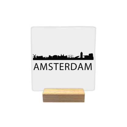 Amsterdam skyline - Decoratie tegel - Formaat: - Op deze decoratie tegel staat een zwarte skyline van de stad Amsterdam afgebeeld tegen een witte achtergrond. Onder de silhouetten van diverse bekende gebouwen en een molen staat in zwarte letters de naam Amsterdam. Het ontwerp is minimalistisch uitgevoerd in alleen zwart en wit. - Snelwenskaart