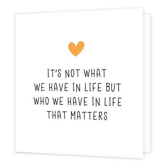 Mini bloemenkaartje - It's not what we have in life - Formaat: Klein - Vorm: Vierkant - Vriendschapskaart - Op deze wenskaart staat een oranje hartje met daaronder de tekst: "It's not what we have in live but who we have in life that matters". - Snelwenskaart