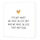 Mini bloemenkaartje - It's not what we have in life - Formaat: Klein - Vorm: Vierkant - Vriendschapskaart - Op deze wenskaart staat een oranje hartje met daaronder de tekst: "It's not what we have in live but who we have in life that matters". - Snelwenskaart