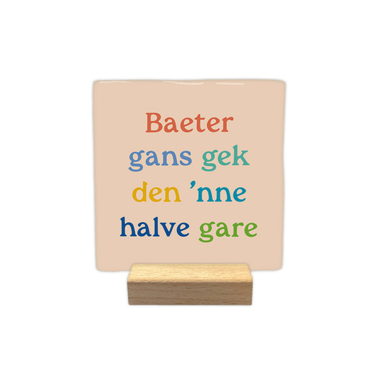 Baeter gans gek den 'nne halve gare - Decoratie tegel - Formaat: - Op deze decoratie tegel staat de tekst "Baeter gans gek den 'nne halve gare". De woorden zijn verdeeld over vier regels en staan op een lichtbeige achtergrond. Elk woord of zinsdeel heeft een eigen kleur, waaronder oranje, blauw, groen, geel en donkerblauw. Het lettertype heeft duidelijke schreven. - Snelwenskaart