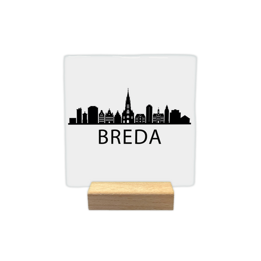 Breda skyline - Decoratie tegel - Formaat: - Op deze decoratie tegel staat een zwarte skyline van Breda afgebeeld tegen een witte achtergrond. Het silhouet bevat diverse herkenbare gebouwen uit de stad. Onder de skyline staat in zwarte letters de naam Breda. Het ontwerp is minimalistisch uitgevoerd in alleen zwart en wit. - Snelwenskaart