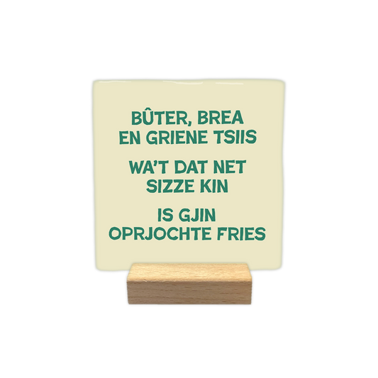 Bûtter, brea en griene tslls - Decoratie tegel - Formaat: - Op deze decoratie tegel staat de tekst "Bûter, brea en griene tsiis, wa't dat net sizze kin is gjin oprjochte Fries" in groene letters centraal afgebeeld. De achtergrond van de tegel is lichtgeel van kleur. - Snelwenskaart