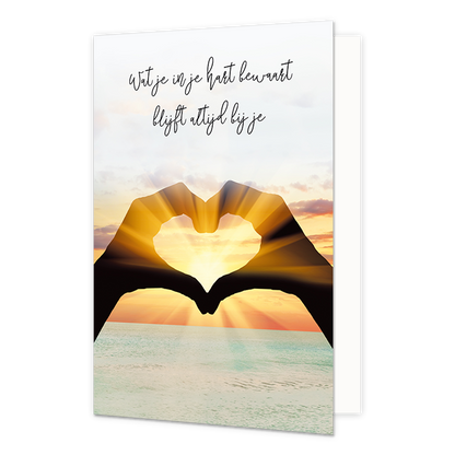 Op deze wenskaart staat de zee met zonsondergang en een hart gemaakt van twee handen met daarboven de tekst: "Wat je in je hart bewaart blijft altijd bij je". 
