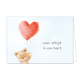 Voor altijd in ons hart - Formaat: Standaard - Vorm: Liggend - Condoleance kaart - Op deze wenskaart staat een zachte illustratie van een lichtbruine teddybeer die een grote, rode ballon in de vorm van een hart vasthoudt. De hartvormige ballon is versierd met subtiele witte spikkels en lijkt licht uit te stralen tegen de lichtblauwe achtergrond. Aan de rechterkant van de kaart staat de tekst "voor altijd in ons hart" geschreven in een eenvoudig, donker lettertype. De gehele afbeelding heeft een dromerige u