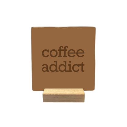 Coffee addict - Decoratie tegel - Formaat: - Op deze decoratietegel staat de tekst "coffee addict" in donkerbruine letters. De tekst is gecentreerd op een bruine achtergrond. - Snelwenskaart