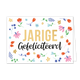 Jarige gefeliciteerd - Formaat: Standaard - Vorm: Liggend - Verjaardagskaart - Op deze wenskaart zijn diverse bloemen allerlei soorten bloemen zichtbaar in de kleuren rood, roze, blauw en geel. In het midden staat de tekst "Jarige gefliciteerd" waarbij de tekst "Jarige" groots en in goud geschreven staat. - Snelwenskaart