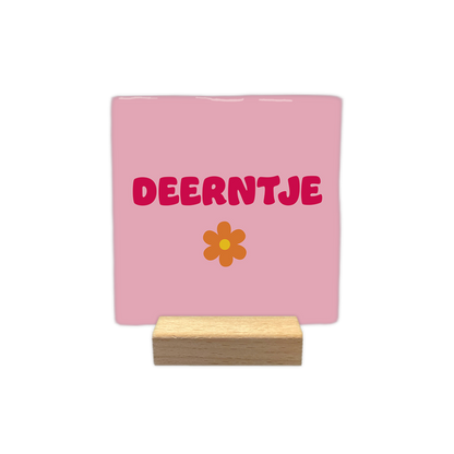 Deerntje - Decoratie tegel - Formaat: - Op deze decoratie tegel staat de tekst "deerntje" in roze letters centraal afgebeeld. Onder de tekst is een oranje bloem met een geel hartje getekend. De achtergrond van de tegel is lichtroze van kleur. - Snelwenskaart