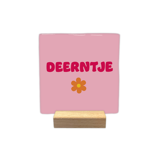 Deerntje - Decoratie tegel - Formaat: - Op deze decoratie tegel staat de tekst "deerntje" in roze letters centraal afgebeeld. Onder de tekst is een oranje bloem met een geel hartje getekend. De achtergrond van de tegel is lichtroze van kleur. - Snelwenskaart
