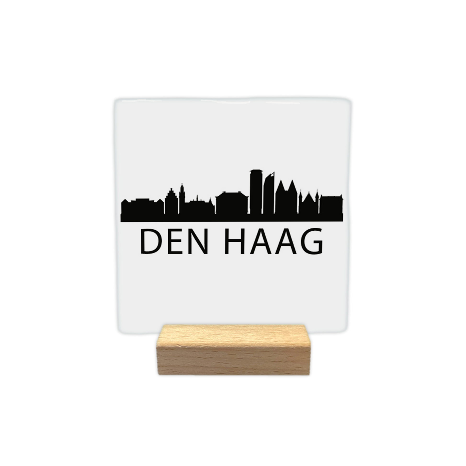 Den Haag skyline - Decoratie tegel - Formaat: - Op deze decoratie tegel staat een zwarte skyline van Den Haag afgebeeld tegen een witte achtergrond. Het silhouet toont diverse herkenbare gebouwen uit de stad. Onder de skyline staat in zwarte letters de plaatsnaam Den Haag. Het gehele ontwerp is uitgevoerd in een minimalistische zwart-witstijl. - Snelwenskaart