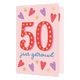 50 jaar getrouwd - Formaat: Standaard - Vorm: Staand - Verjaardagskaart - Op deze wenskaart staat de tekst "50 jaar getrouwd" centraal tegen een lichtroze achtergrond. Het getal "50" is groot uitgevoerd in het rood en versierd met goudkleurige stippen, wat doet denken aan feestverlichting. Daaronder staat de tekst "jaar getrouwd" in blauwe, handgeschreven letters. De tekst wordt omringd door vrolijke illustraties van rode en blauwe hartjes en goudkleurige sterretjes. - Snelwenskaart