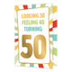 Turning 50 - Formaat: Standaard - Vorm: Staand - Verjaardagskaart - Op deze wenskaart staan lijnen in de kleuren rood, groen, blauw en geel. In het midden zit een wit vlak met de tekst: "Looking 30 feeling 40 turning 50". - Snelwenskaart