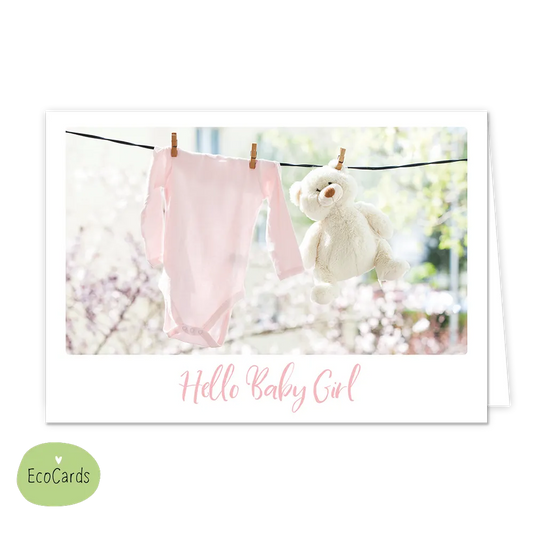Hello baby girl - Afmeting: {"value":13.4,"unit":"CENTIMETERS"} x {"value":9.7,"unit":"CENTIMETERS"} - Formaat: Klein - Vorm: Liggend - Geboortekaart - Op deze wenskaart staat een waslijn waar een roze rompertje en een knuffel aan hangen. Onder de illustratie staat de tekst: "Hello baby girl". - Snelwenskaart