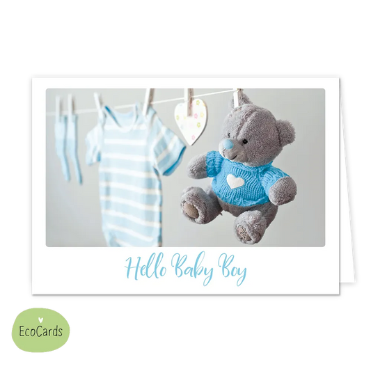 Hello baby boy - Afmeting: {"value":13.4,"unit":"CENTIMETERS"} x {"value":9.7,"unit":"CENTIMETERS"} - Formaat: Klein - Vorm: Liggend - Geboortekaart - Op deze wenskaart staat een waslijn waar een blauw rompertje en een knuffel aan hangen. Onder de illustratie staat de tekst: "Hello baby boy". - Snelwenskaart