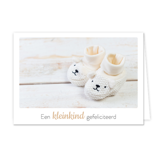 Een kleinkind gefeliciteerd - Formaat: Klein - Vorm: Liggend - Geboortekaart - Op deze wenskaart staan witte kinderschoentjes met daaronder de tekst: "Een kleinkind gefeliciteerd". - Snelwenskaart