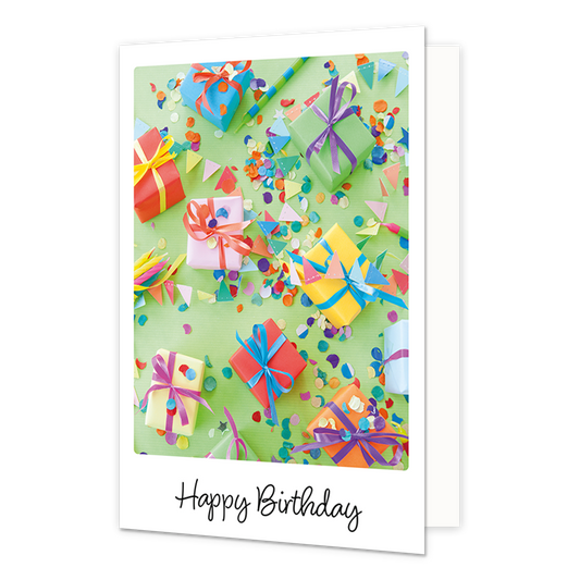 Op deze wenskaart is een kleurrijke verzameling van ingepakte cadeautjes en strooiconfetti te zien op een lichtgroene achtergrond. De diverse geschenken zijn versierd met gekleurde linten en strikken, omringd door kleine driehoekige vlaggetjes en feestelijke snippers. Onderaan de illustratie staat in een zwart, handgeschreven lettertype de tekst "Happy Birthday".