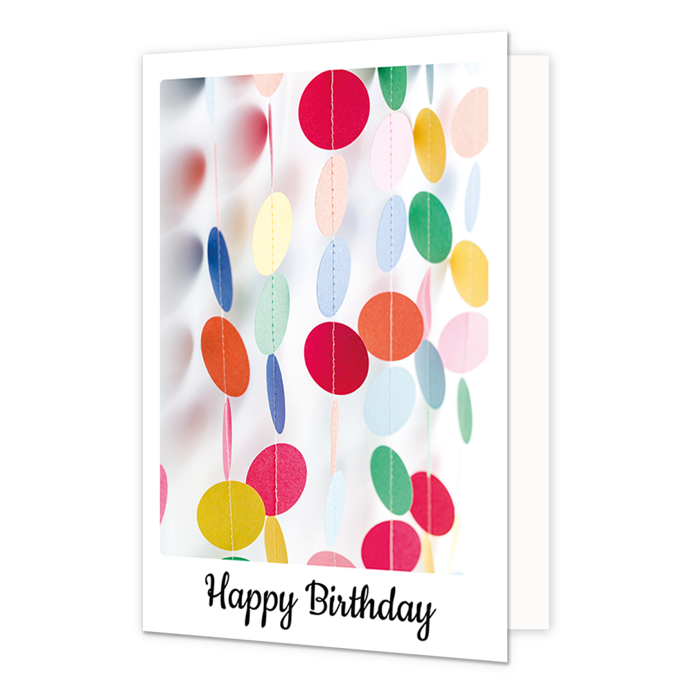 Happy birthday - Formaat: Klein - Vorm: Staand - Verjaardagskaart - Op deze wenskaart is een kleurrijke illustratie te zien van verticale slingers bestaande uit ronde, papieren schijfjes in diverse kleuren zoals rood, geel, blauw en groen. De achtergrond van de afbeelding is wit en helder, waarbij sommige slingers op de voorgrond scherp zijn en andere op de achtergrond vervaagd worden weergegeven. Onderaan de witte rand van de kaart staat in een zwart, sierlijk handschrift de tekst "Happy Birthday". De geh