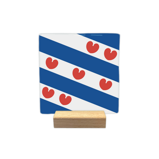 Friesland - Decoratie tegel - Formaat: - Op deze decoratie tegel staat een ontwerp met diagonale blauwe en witte banen. Over deze banen heen zijn zeven rode figuren geplaatst die de vorm hebben van bladeren of hartjes. Dit ontwerp is gebaseerd op de vlag van de provincie Friesland. - Snelwenskaart